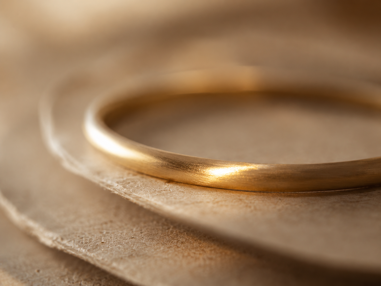 Gold band on layered craft paper, a material study in warmth